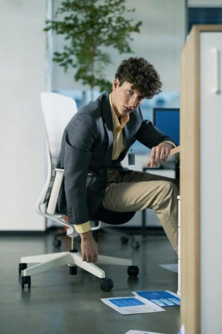 Person experiencing back and neck pain while working at a computer in a poorly designed home office setup