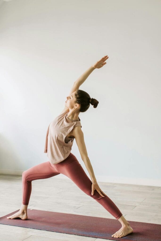 Essential Health and Wellbeing Tips, with a person practicing yoga for physical and mental wellbeing at home