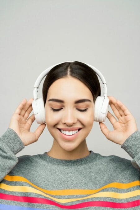 A professional woman working from home wearing the best noise-cancelling headphones for remote work, focusing on a Zoom call at her home office desk.